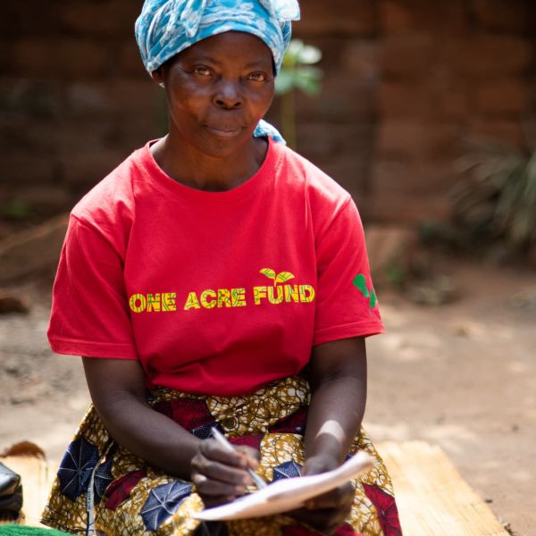 A Malawian farmer sits with her notebook during a training session on carbon credits