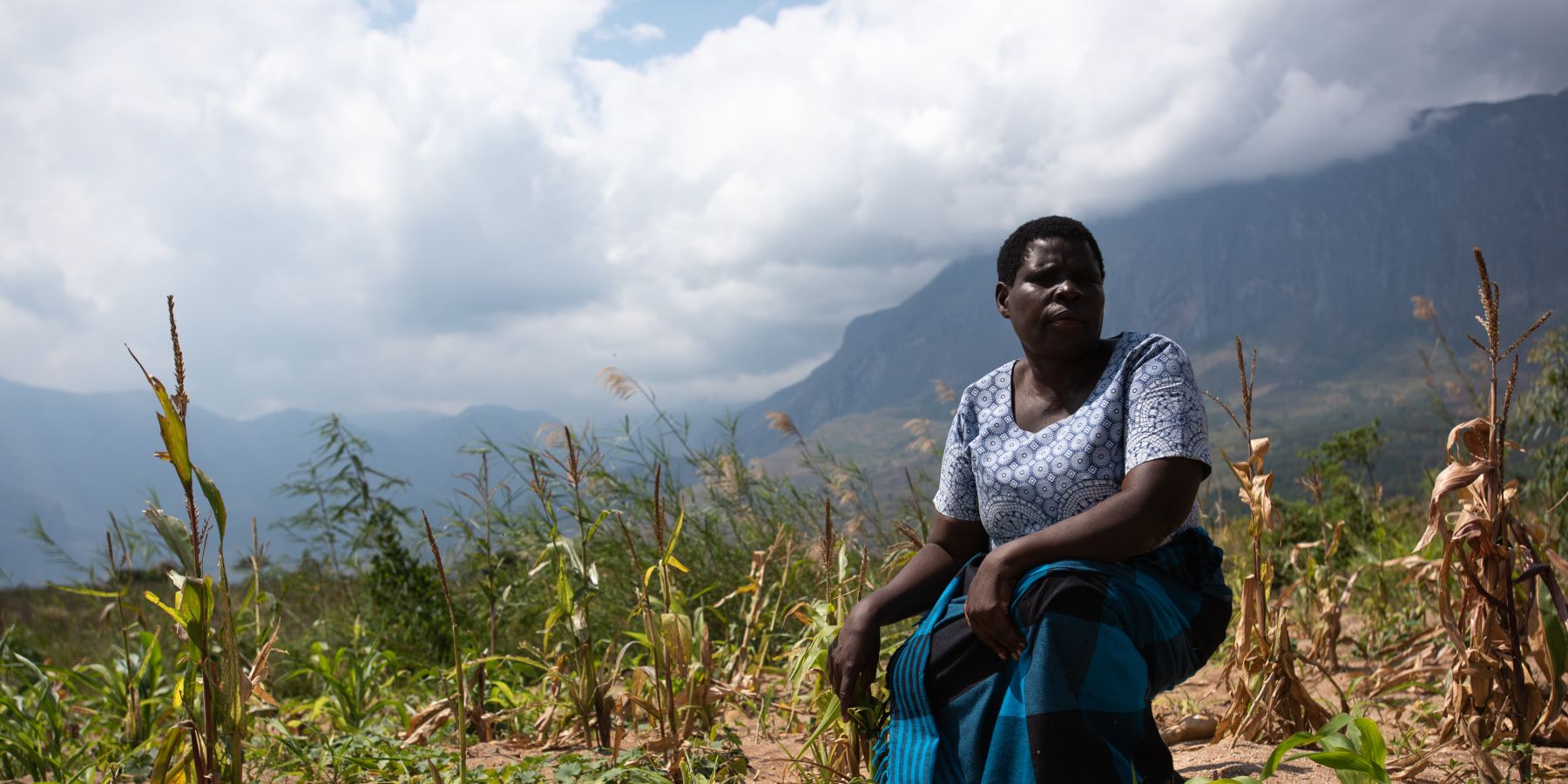 Enife, a farmer in Malawi stands in her devastated field