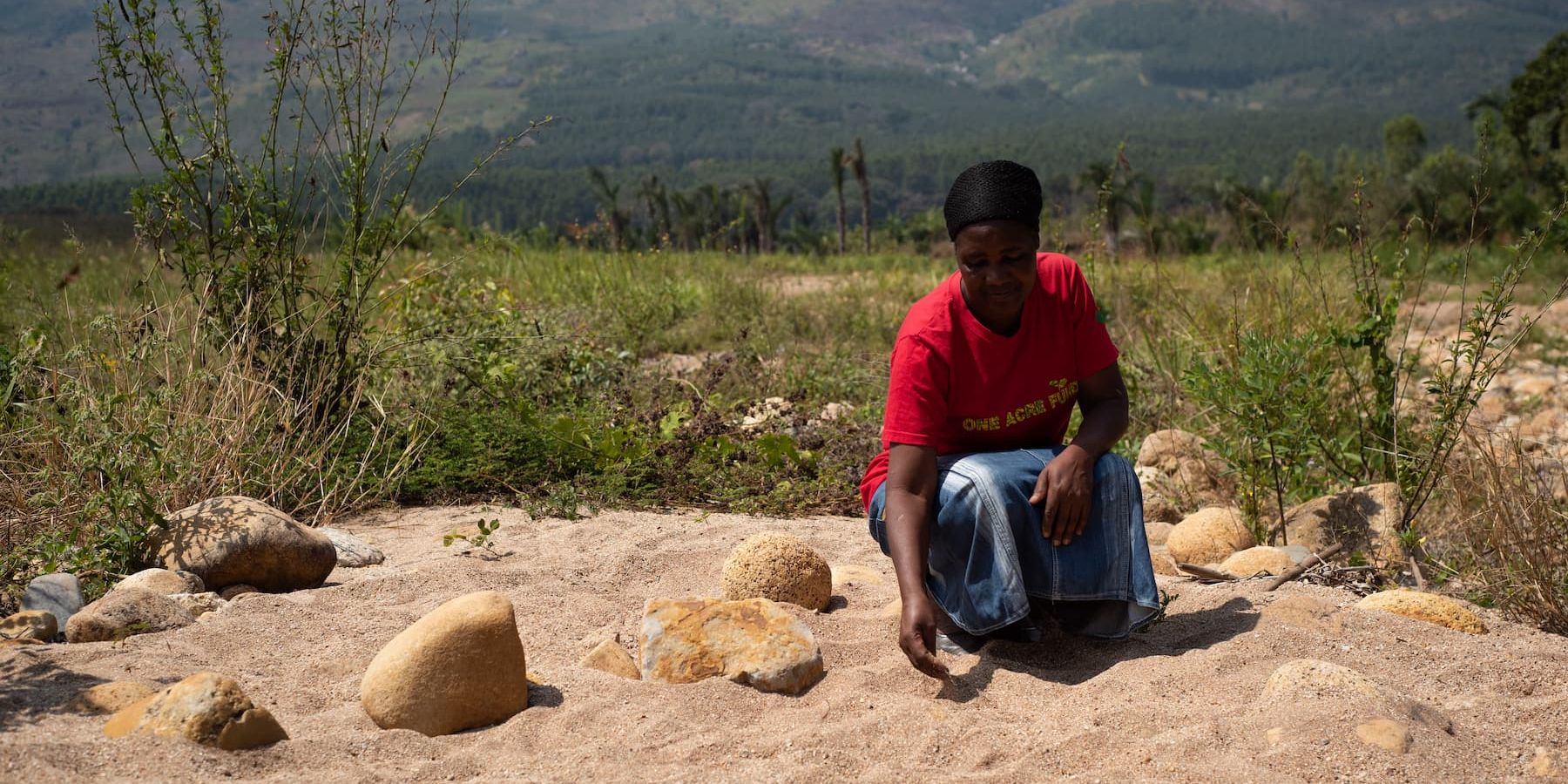 Malawian farmer Khadija Kendrick sits in her land ruined by Cyclone Ana