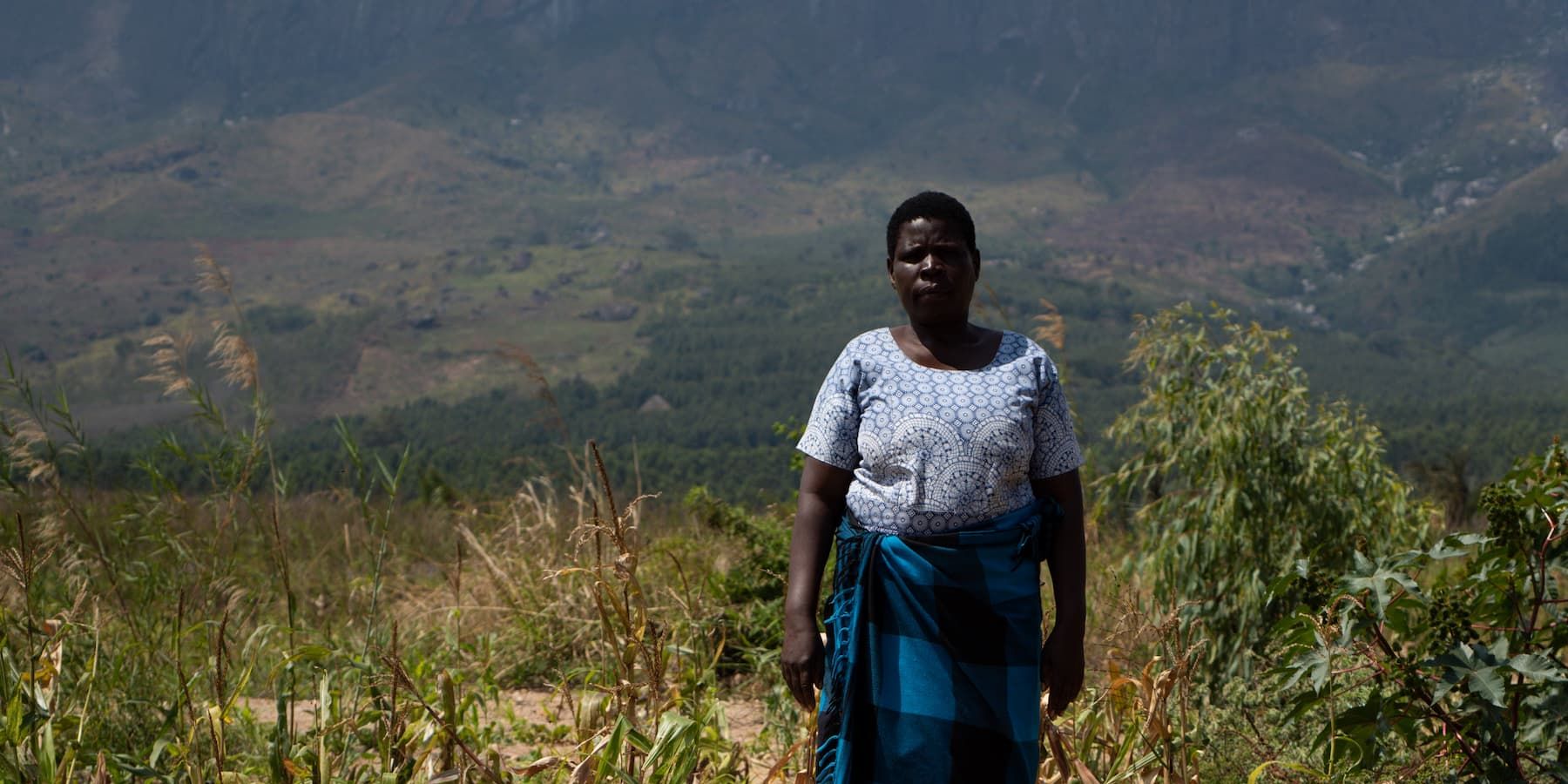 Enife Matemba stands in her destroyed field in Mulanje, Malawi
