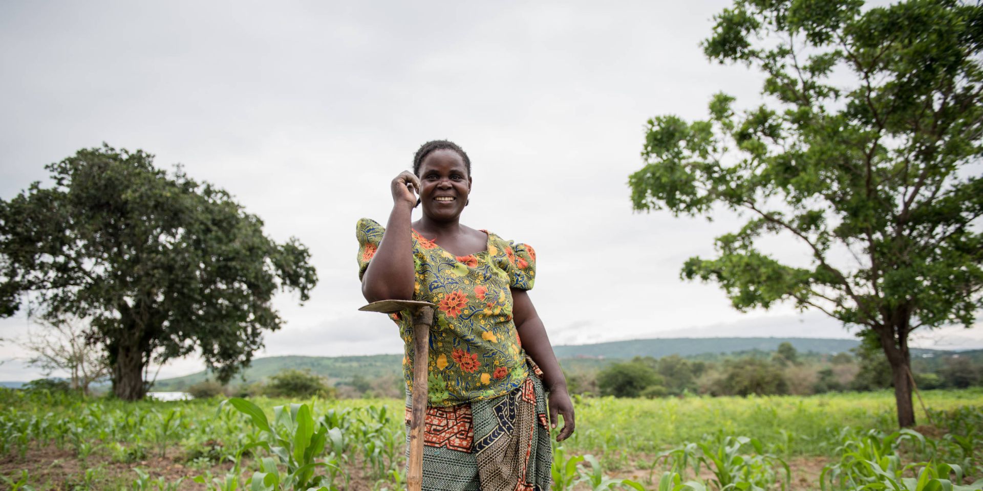 A woman farmer posing in her field full of crops