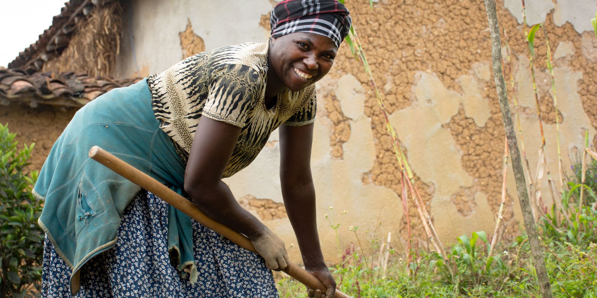 A smiling woman farmer tills her land