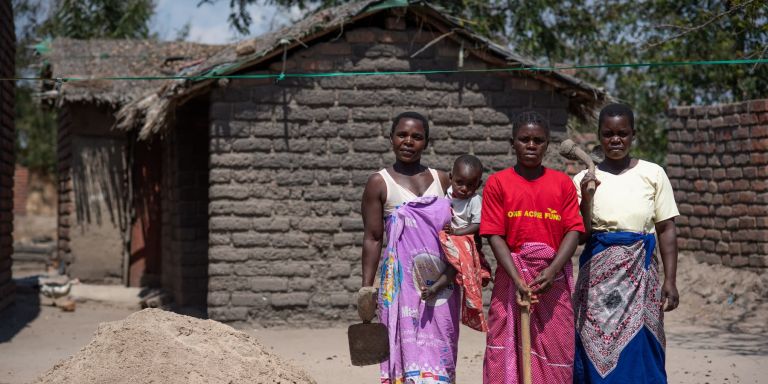 A Malawian family impacted by a recent cyclone stand in their compound