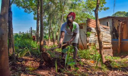 A young farmer tills her land in Kenya