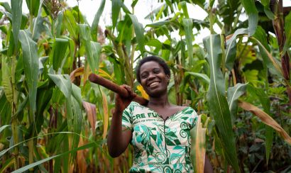 Asterie Ntahonvukiye, a farmer in Burundi, stands smiling in her maize field