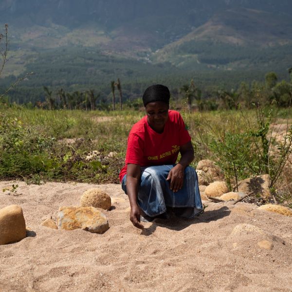 Malawian farmer Khadija Kendrick sits in her land ruined by Cyclone Ana