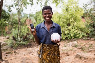 Woman holding solar charger and mobile phone