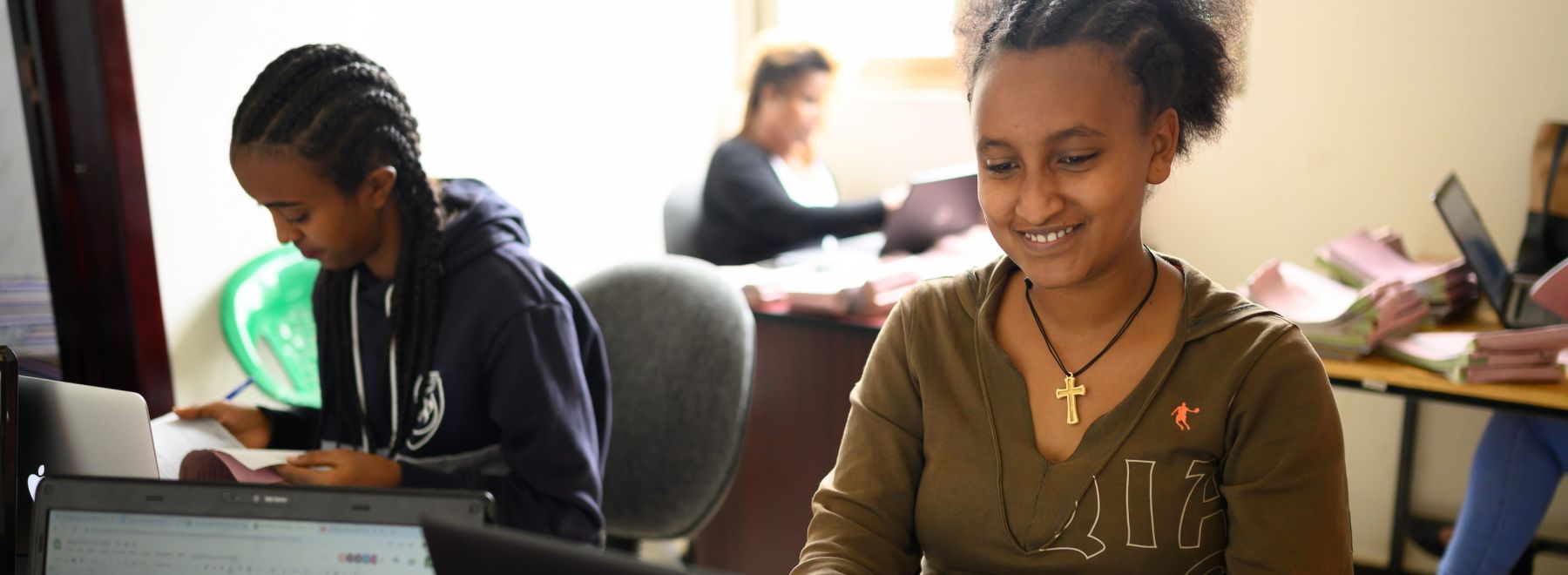 A One Acre Fund staff member in Bahir Dar, Ethiopia smiles as she works at her laptop
