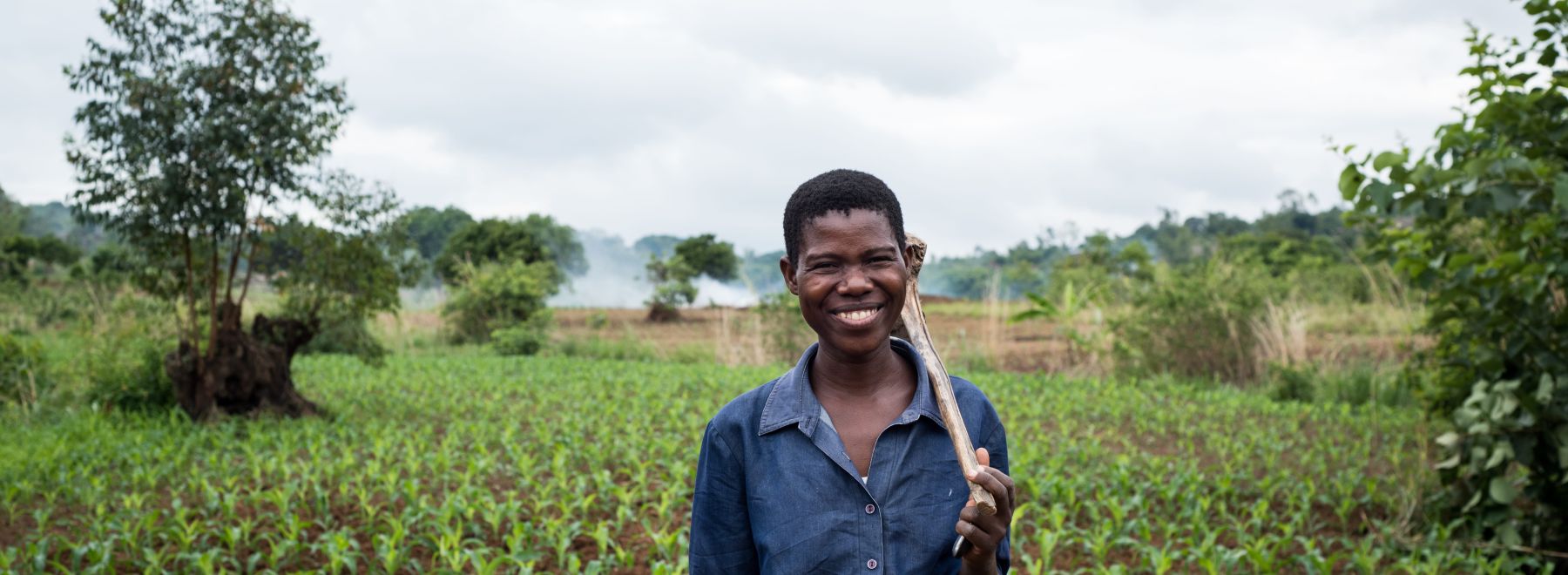 A farmer in Malawi stands in her field