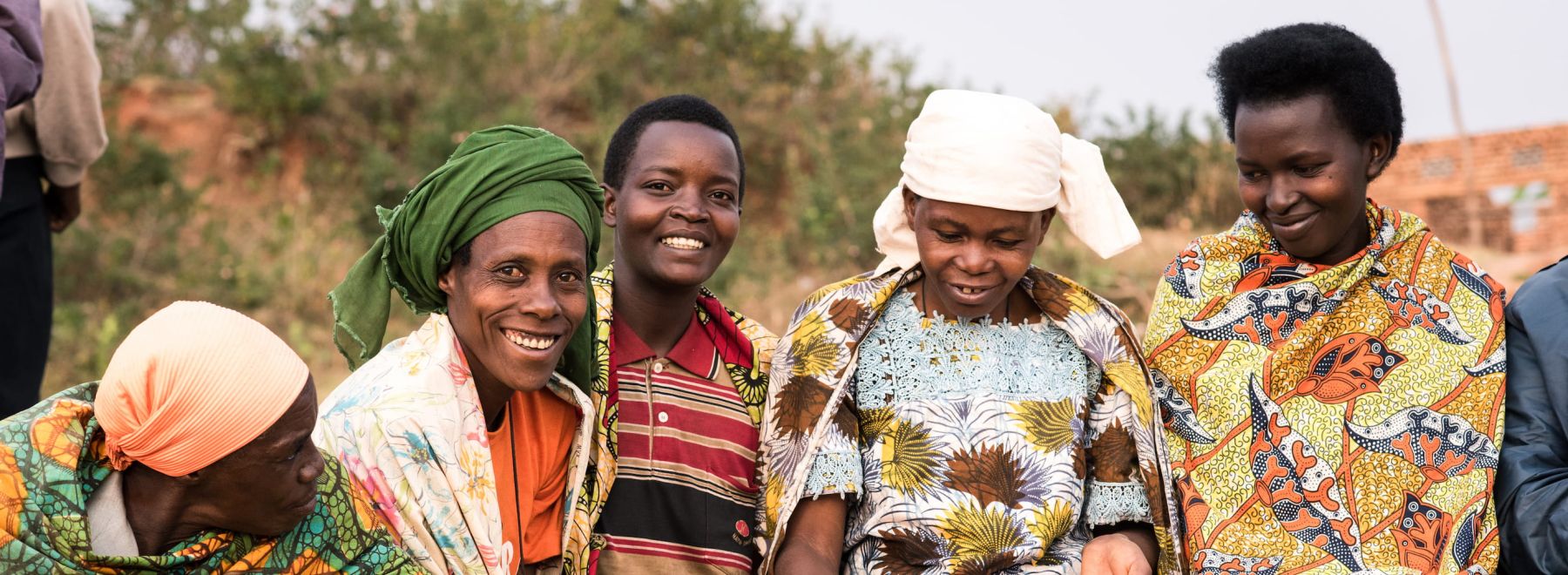 Farmers in Burundi attend a group meeting - here they're smiling at the camera