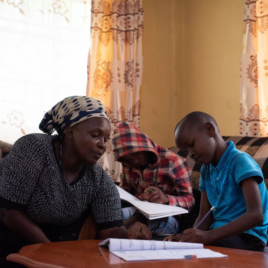 Esther, a Kenyan smallholder, helps her children with their homework