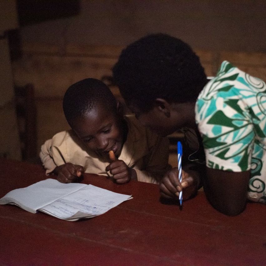 Asterie Ntahonvukiye helping her child study in their home