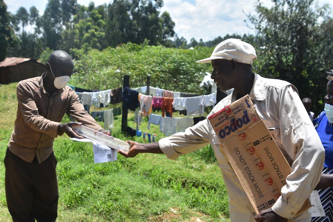 Field officer handing over soap to a farmer