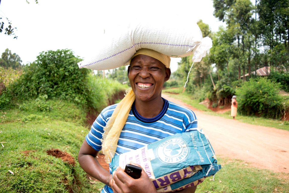 Woman farmer carrying bag of seeds