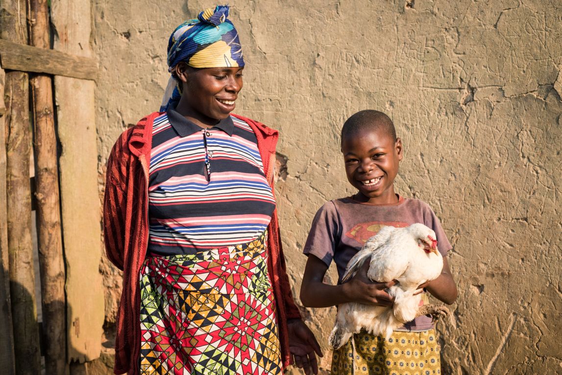 A farmer and her daughter from Rwanda holding their chickens